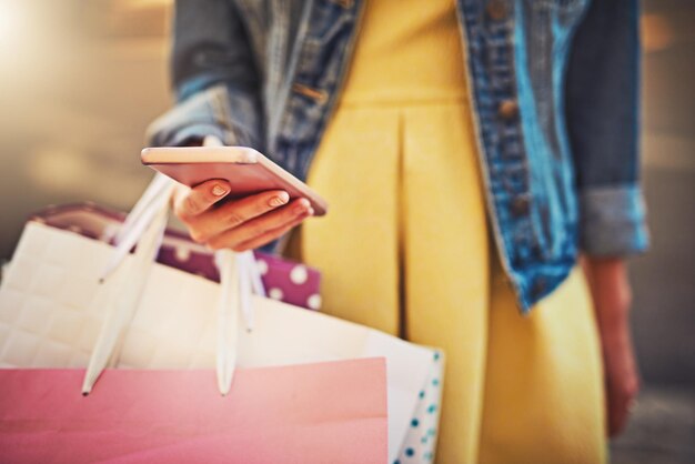 Photo woman hands closeup and shopping bag with phone for scroll with retail reading for info on discount fashion female person online search and mobile app for store with sale check on social media