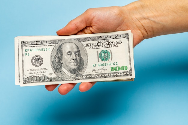 Woman hands counting dollar banknotes on blue 