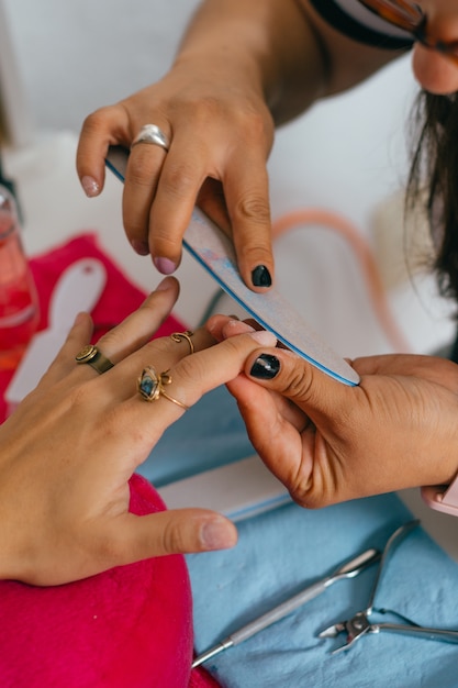 Woman hands doing manicure in salon.