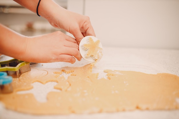 Woman hands form molds cutters ginger dough and makes delicious christmas ginger cookies Cooking and decorating christmas dessert