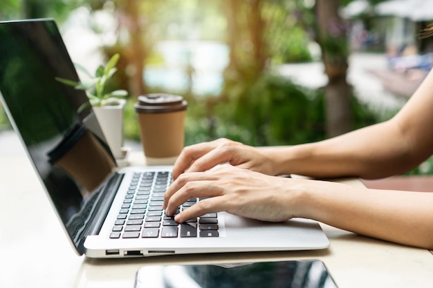 Woman hands freelancer is working on laptop computer Work from home business and technology concept Closeup