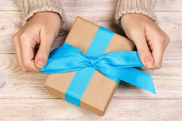 Woman hands give Present gift  box top view