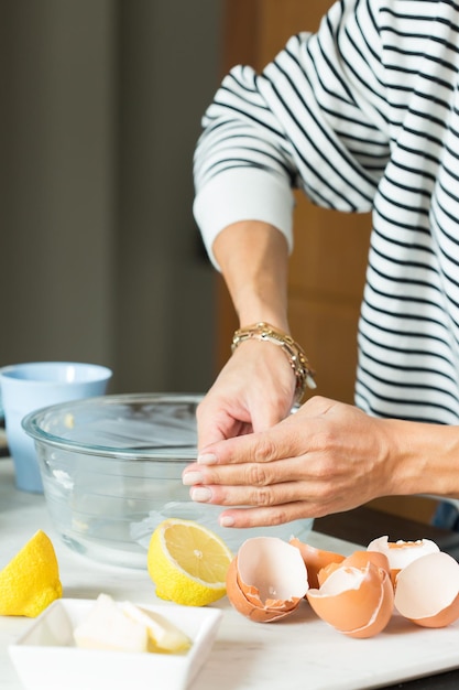 Woman hands greasing the baking dish while cooking apple pie