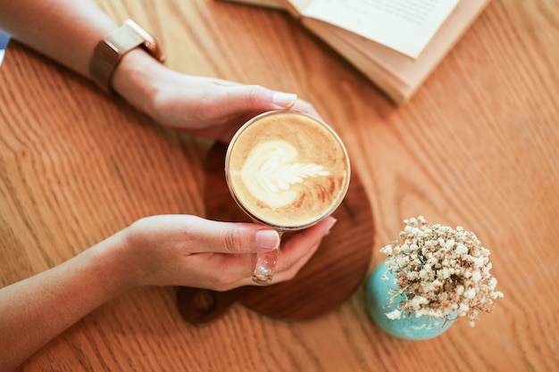 Woman hands  holding cup of coffeeÂ with latte art. holding cup of tea or coffee in the morning.