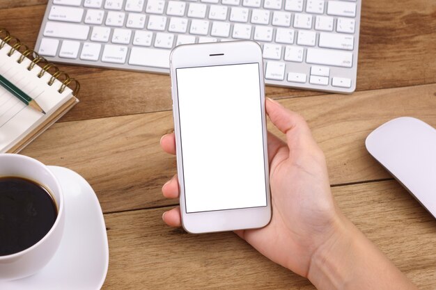 woman hands holding empty screen of smartphone on wood 