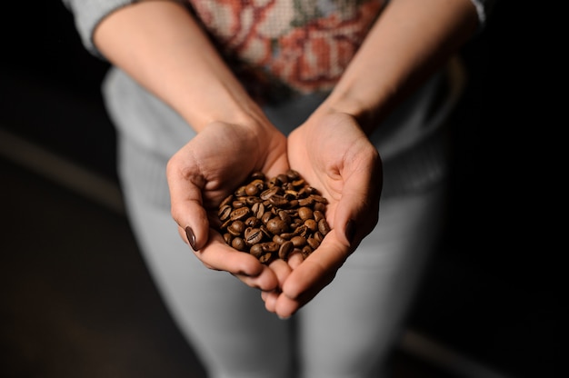 Woman hands holding a handful of fresh coffee beans