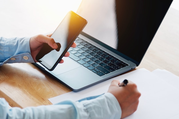 Woman hands holding smart phone using working in office