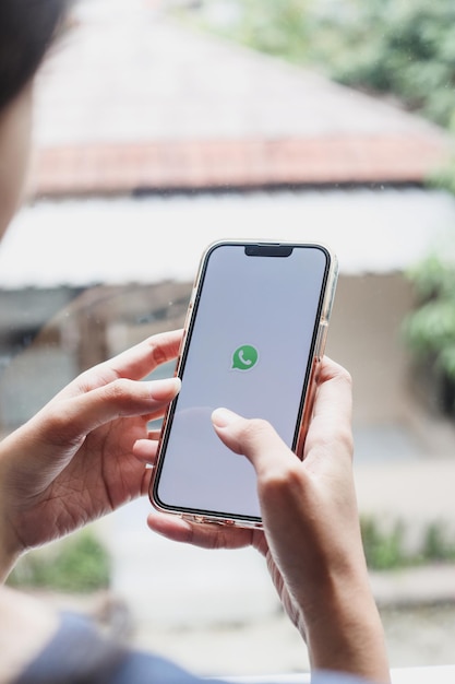 Woman hands holding a smartphone with messenger Whatsapp application on the screen. Girl chatting th