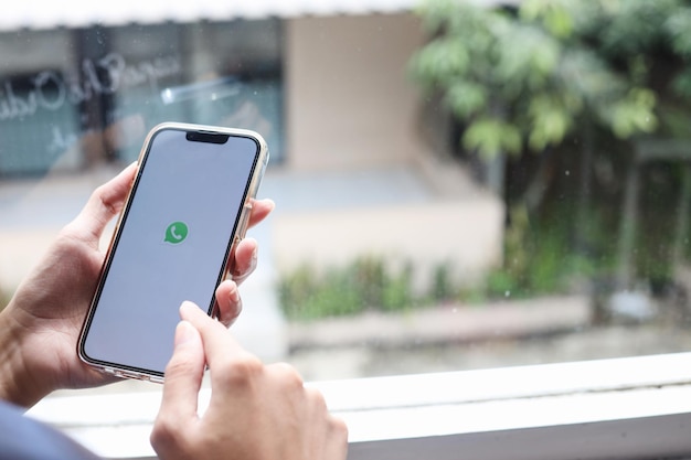 Woman hands holding a smartphone with messenger Whatsapp application on the screen. Girl chatting th