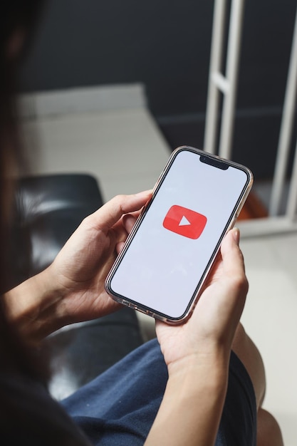 Woman hands holding a smartphone with Youtube apps on screen. YouTube is the popular online video sh