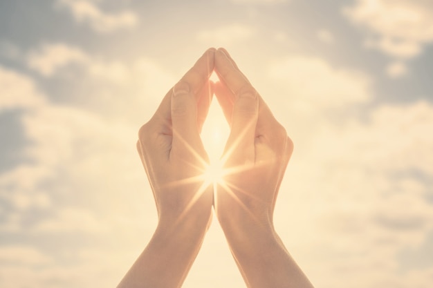 Woman hands holding the sun at dawn