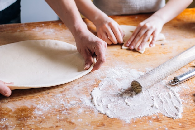 Woman hands kneading dough on the table