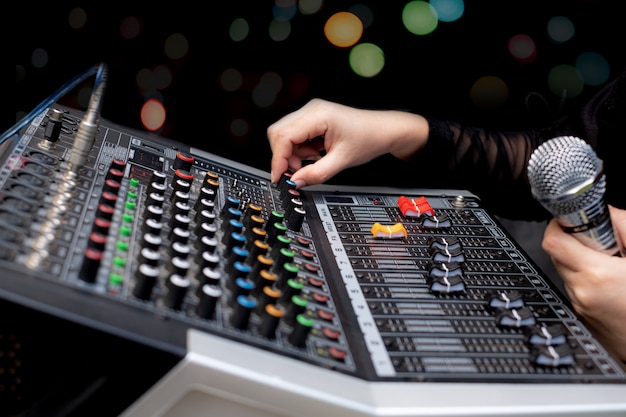 Woman hands mixing audio by sound mixer analog