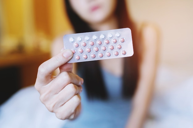 Woman hands opening birth control pills in hand. Eating Contraceptive Pill.