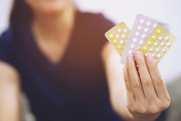 Woman hands opening birth control pills in hand. Eating Contraceptive Pill.