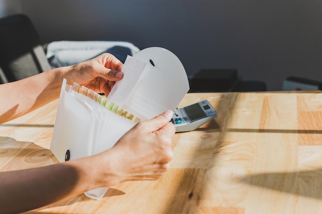 Woman hands organizing folder on a desk at home