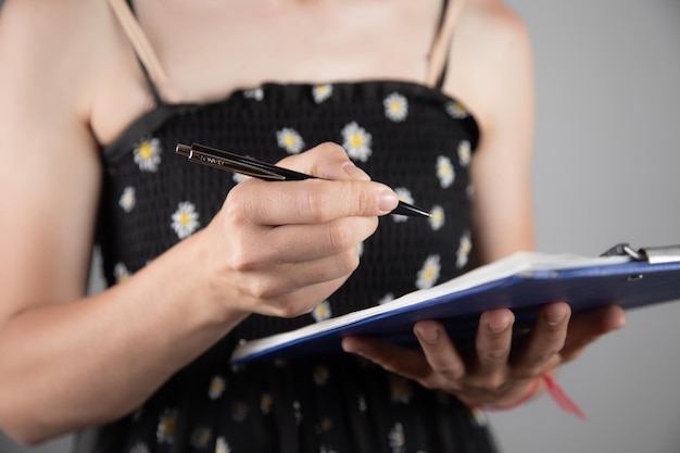 Woman hands paper in a clipboard with pen