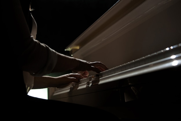 Woman hands playing a piano, musical instrument