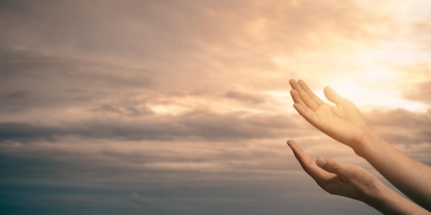 Woman hands praying for blessing from god with sunlight on sunset backgroundxA