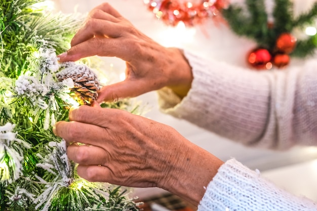 Woman hands preparing little Christmas tree with decorations and snow Holiday event new year