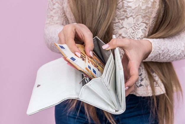 Woman hands put euro banknotes into purse