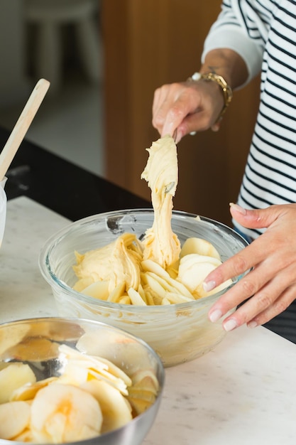 Woman hands putting dough while cooking apple pie