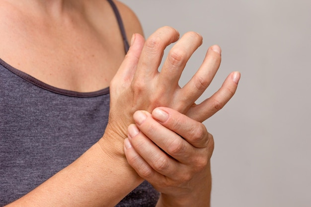 Photo woman hands showing hand with arthritis over cropped body