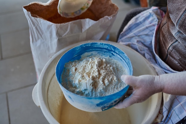 Woman hands sifting flour with flour filter