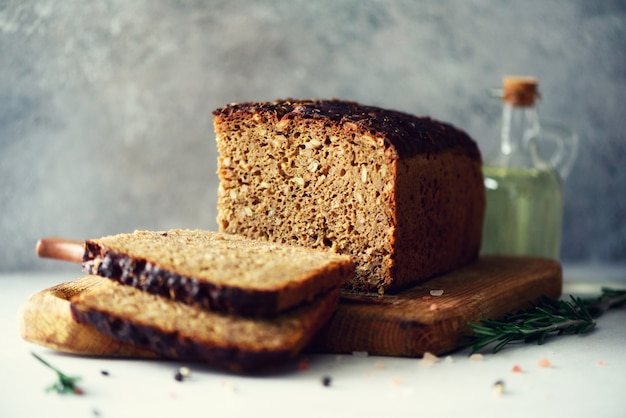 Woman hands slicing freshly backed bread. Handmade brown loaf of bread, bakery concept, homemade food, healthy eating. Copy space