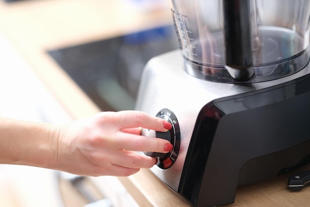 Woman hands switch gears on mixer in kitchen