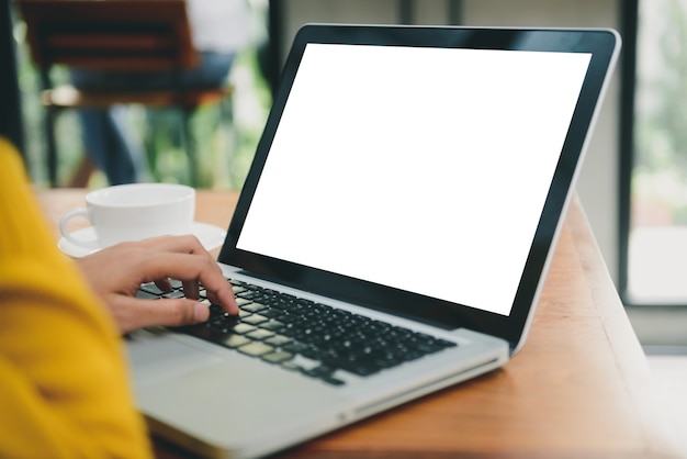 Woman hands typing laptop computer with blank screen for mock up template background