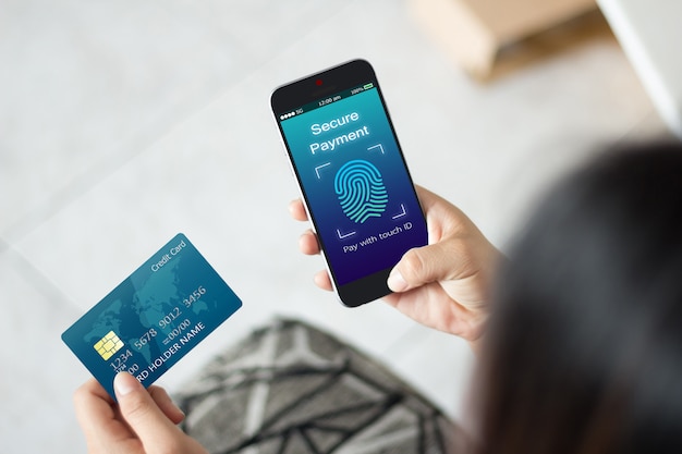 Woman hands using mobile phone and credit card