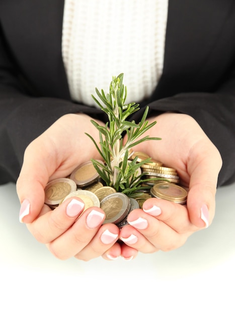 Photo woman hands with green plant and coins isolated on white