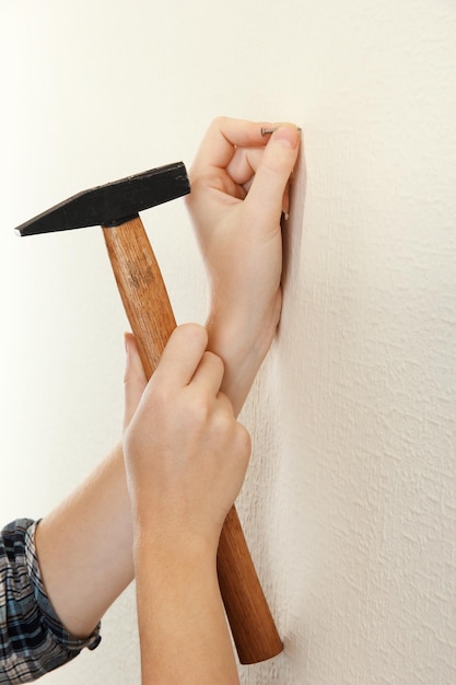 woman hands with nail and hammer