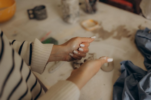 Photo woman hands working on pottery wheel making a clay pot raw clay shaping traditional craft