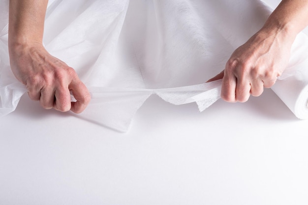 Woman hands working with Covering Roll for Medical Bed