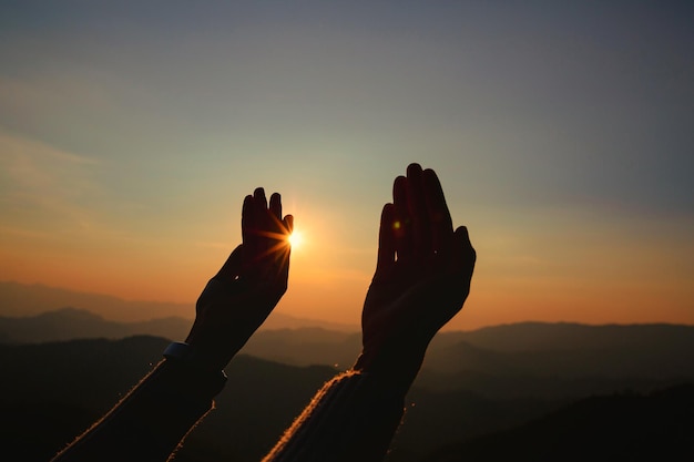 Woman hands worship on sunset