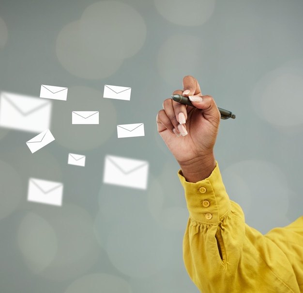 Woman hands and writing with email icons for communication advertising or marketing on mockup Hand of female person holding pen with envelopes for planning networking or online notes on space