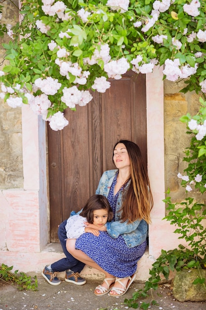 Woman and handsome baby boy sitting near the ancient door