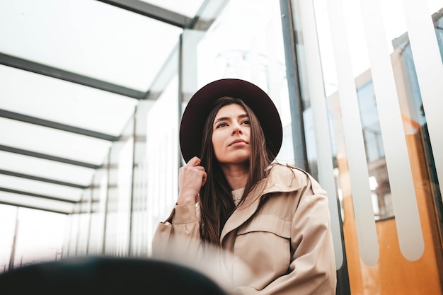 Woman in hat and coat sitting at the bus stop