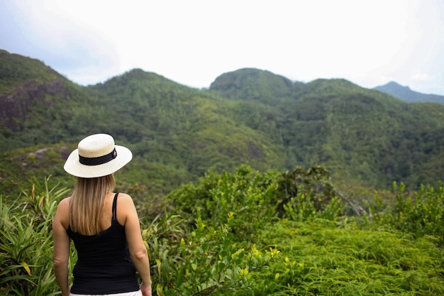 A woman in a hat stands with her back looking at the island