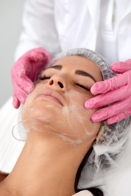 Woman having cleaning facial treatment in spa