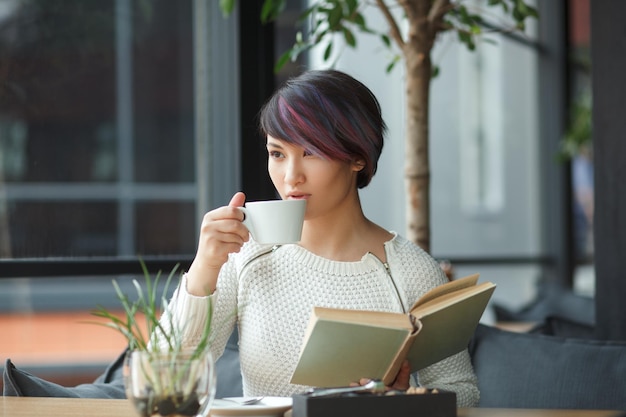 Woman having coffee and reading book