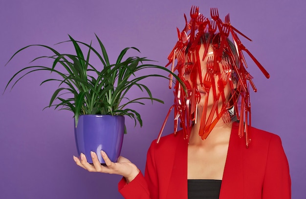 Woman having her face covered in plastic while holding a plant