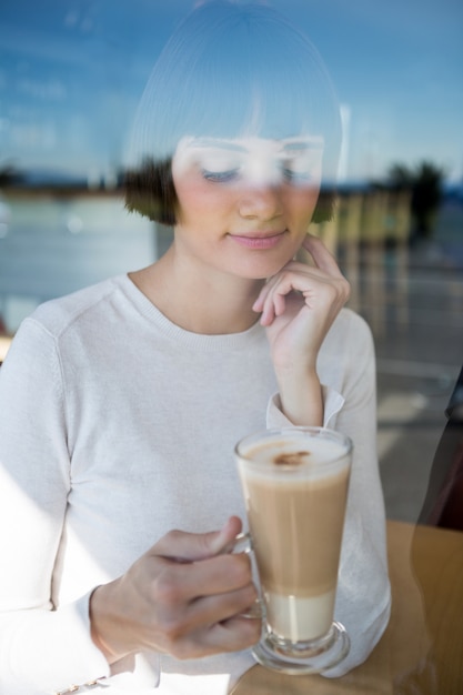 Woman having milkshake in cafeteria