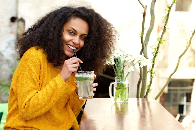 Woman having refreshing drink at outdoor cafe