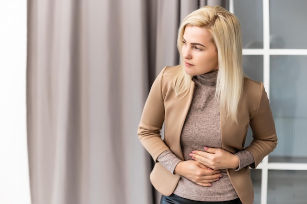 Woman having stomach ache at home.