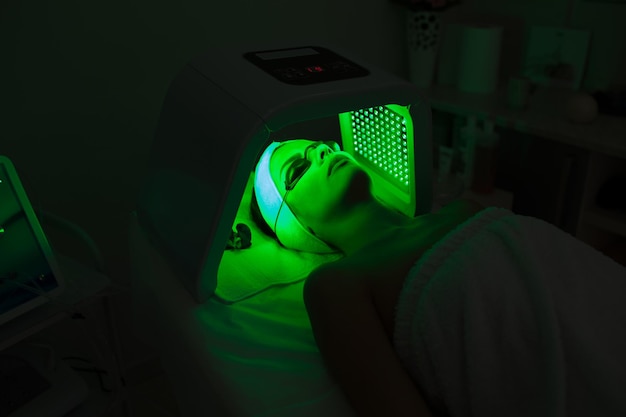 Woman having Ultraviolet LED light facial treatment at beauty salon