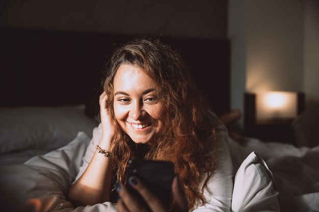 Woman having video call communicating using cell phone at home