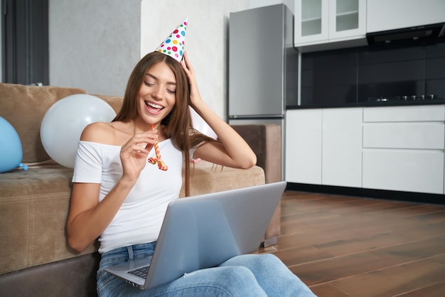 Woman having video call on laptop during birthday at home